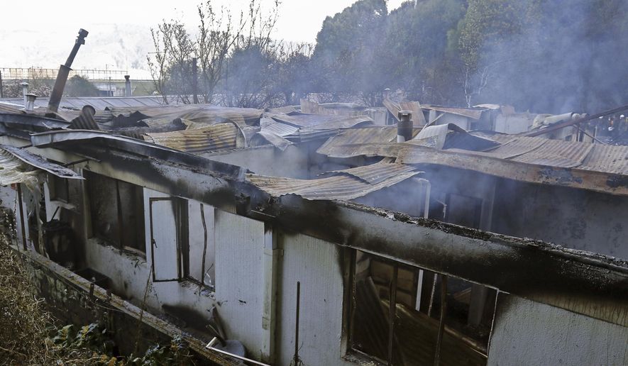 A nursing home building smolders after fire in which at least ten elderly persons died, in Chiguayante, Chile, Tuesday, Aug. 14, 2018. At least Ten elderly persons died in the voracious fire that destroyed the bedroom in which they rested, informed the governor of Bío Bio, Jorge Ulloa. (Alejandro Zonez/Aton Chile via AP)