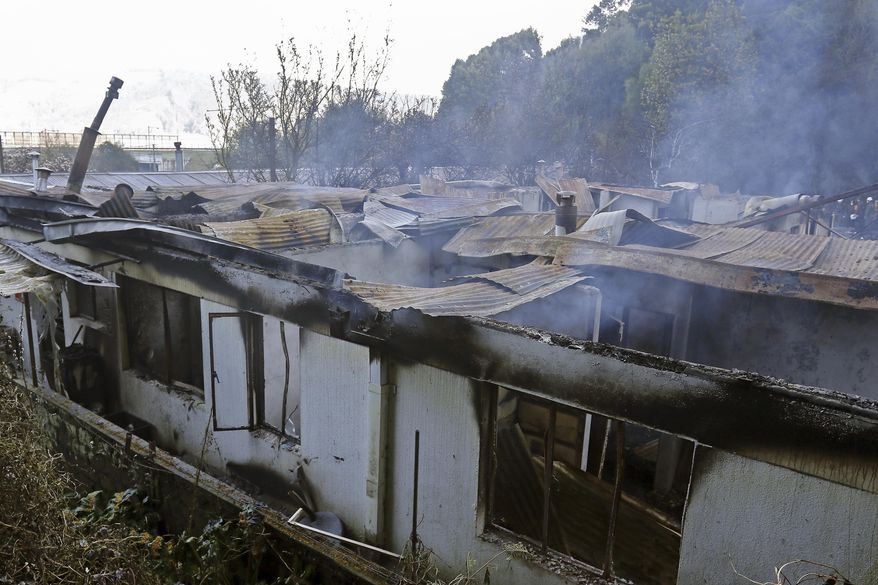 A nursing home building smolders after fire in which at least ten elderly persons died, in Chiguayante, Chile, Tuesday, Aug. 14, 2018. At least Ten elderly persons died in the voracious fire that destroyed the bedroom in which they rested, informed the governor of Bío Bio, Jorge Ulloa. (Alejandro Zonez/Aton Chile via AP)