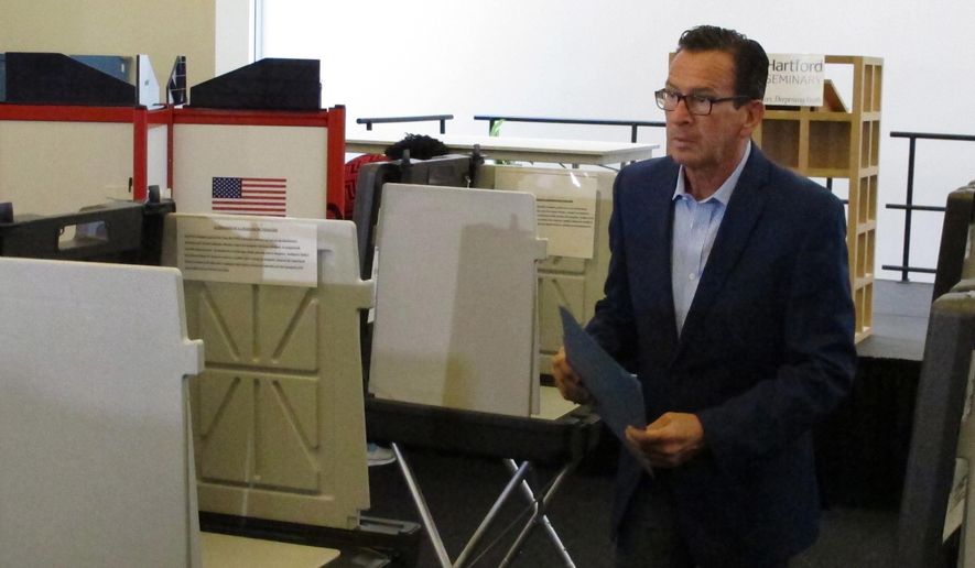 Gov. Dannel P. Malloy prepares to submit his ballot for the primary election at a polling place in Hartford, Conn., on Tuesday, Aug. 14, 2018. The Democratic governor is not seeking a third term. The Connecticut primary elections feature candidates for governor, lieutenant governor, Congress and other statewide offices. (AP Photo/Dave Collins)