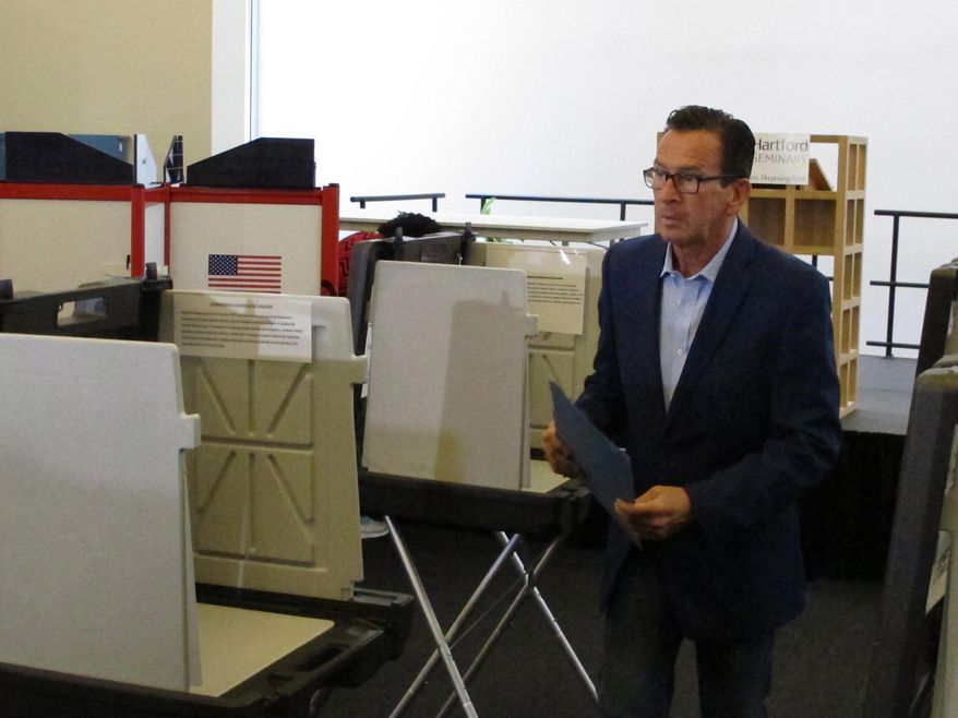 Gov. Dannel P. Malloy prepares to submit his ballot for the primary election at a polling place in Hartford, Conn., on Tuesday, Aug. 14, 2018. The Democratic governor is not seeking a third term. The Connecticut primary elections feature candidates for governor, lieutenant governor, Congress and other statewide offices. (AP Photo/Dave Collins)