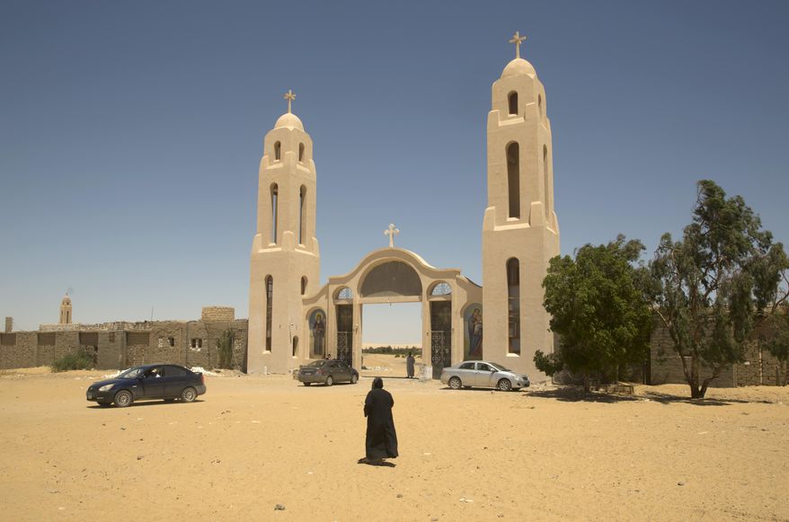 FILE - In this May 27, 2017 file photo, a priest walks in front of St. Samuel the Confessor Monastery in Maghagha, Egypt. The killing of a respected bishop in a desert monastery north of Cairo has opened a rare window onto the cloistered world of Egypt’s Coptic Orthodox Church. It’s one of the oldest Christian communities in the world and the one that introduced monasticism to the faith. But the killing of the abbot, and the arrest of two monks suspected in his death, has shaken the church. (AP Photo/Amr Nabil, File)