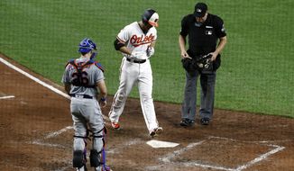 Baltimore Orioles&#39; Chris Davis, center, crosses home plate in front of New York Mets catcher Kevin Plawecki, left, and umpire Jeff Nelson after rounding the bases on a solo home run in the seventh inning of a baseball game, Tuesday, Aug. 14, 2018, in Baltimore. (AP Photo/Patrick Semansky)