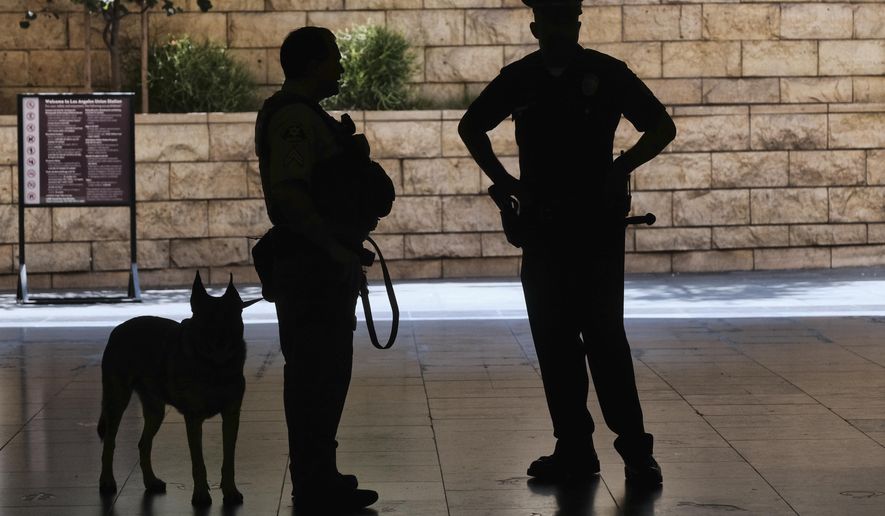 In this file photo, Los Angeles Metro Police and K-9 stand at the entrance to Union Station in Los Angeles on Tuesday, Aug. 14, 2018 prior to a news conference by The Transportation Security Administration (TSA) administrator David P. Pekoske. (AP Photo/Richard Vogel) **FILE**