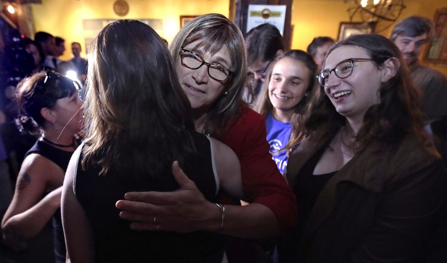 Vermont Democratic gubernatorial candidate Christine Hallquist, center, a transgender woman and former electric company executive, embraces supporters after claiming victory during her election night party in Burlington, Vt., Tuesday, Aug. 14, 2018. (AP Photo/Charles Krupa)
