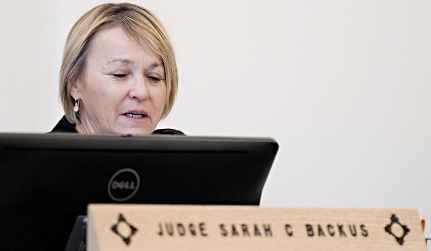 In this Monday, Aug. 13, 2018 photo, District Court Judge Sarah C. Backus presides over the hearing in the Amalia, N.M., desert compound case in Taos, N.M. Backus cleared the way for the release of two men and three women under conditions of house arrest including ankle monitors, despite assertions by prosecutors that the group was training children to use firearms for an anti-government mission and should remain in jail pending trial. Backus' decision to allow the release of an extended family accused of child abuse at a ramshackle desert compound set off a political uproar. (Roberto E. Rosales/The Albuquerque Journal via AP)