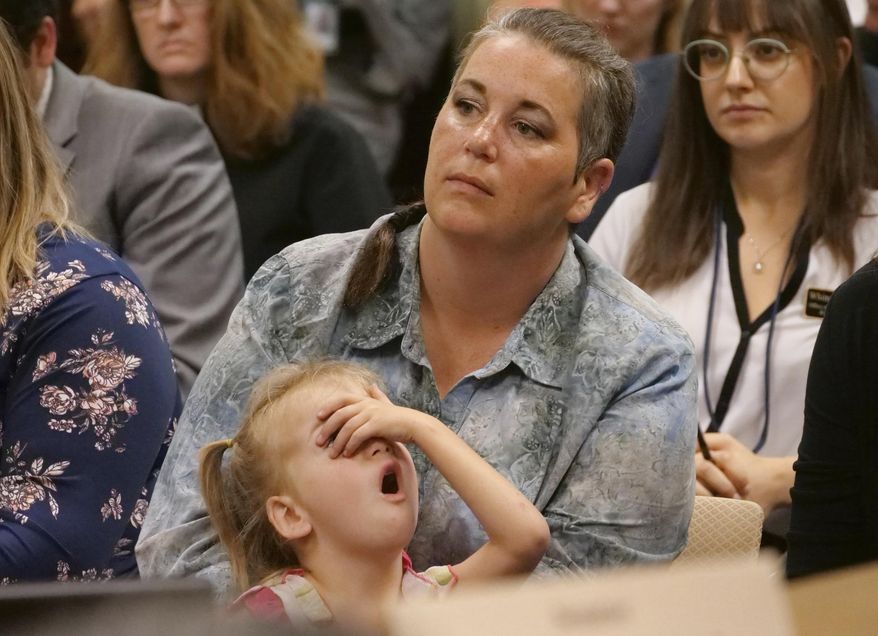 Amie Schofield and her daughter look on during a hearing at the Utah State Capitol Wednesday, Aug. 15, 2018, in Salt Lake City. Parents of transgender and intersex children in Utah are asking state lawmakers to keep allowing their kids to officially change their gender on birth certificates. Amie Schofield said Wednesday she fears her 4-year-old daughter could be bullied or ostracized if school records reveal her birth certificate says she was born a boy. (AP Photo/Rick Bowmer)