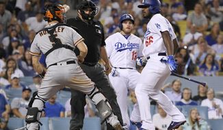 San Francisco Giants catcher Nick Hundley, left, reacts to being shoved by Los Angeles Dodgers&#x27; Yasiel Puig, right, as they argue while home plate umpire Eric Cooper, second from left, gets between them and Max Muncy runs in during the seventh inning of a baseball game, Tuesday, Aug. 14, 2018, in Los Angeles. (AP Photo/Mark J. Terrill)
