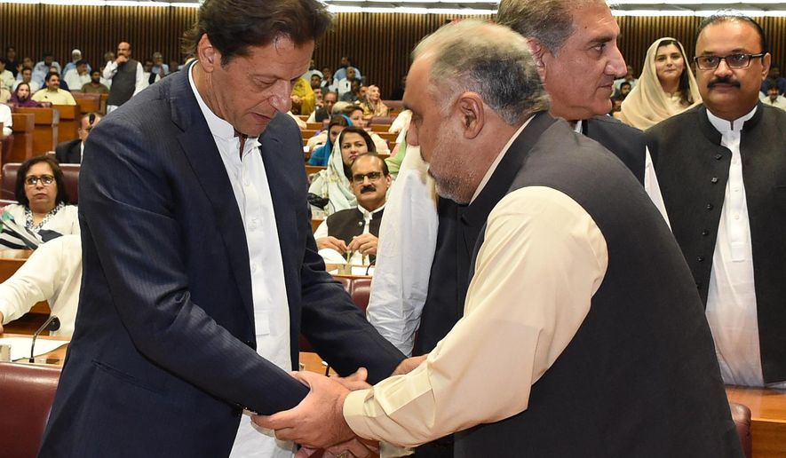 In this photo released by the National Assembly, the leader of Pakistan Tahreek-e-Insaf party Imran Khan, left, greets speaker of the National Assembly Asad Qaiser in Islamabad, Pakistan, Wednesday, Aug. 15, 2018. Pakistan&#39;s lower house of parliament elected Qaiser, an ally of Khan, to be its next speaker on Wednesday, paving the way for the former cricket star and longtime politician to become the next prime minister. (National Assembly, via AP)