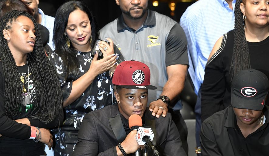 FILE - In this Feb. 7, 2018, file photo, Patrick Surtain Jr. is interviewed with his family behind him, after announcing he is signing with Alabama on national signing day in Plantation, Fla. Alabama needs immediate help in the secondary after losing its top six defensive backs from last year’s national championship team. That should create an early opportunity for Surtain, rated by the 247Sports Composite as the nation’s No. 1 cornerback and No. 6 overall prospect in his class. (Taimy Alvarez/South Florida Sun-Sentinel via AP, File)