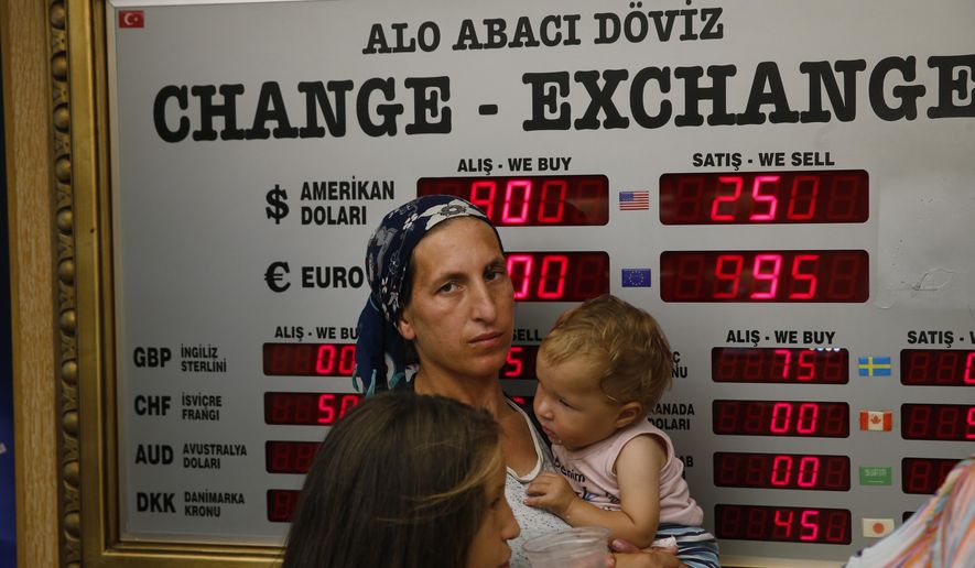 People wait at a currency exchange shop in Istanbul, Wednesday, Aug. 15, 2018. The Turkish lira has nosedived in value in the past week, but some Turks are reacting with defiance to their plunging currency and an escalating trade and political dispute with the United States. (AP Photo/Lefteris Pitarakis)