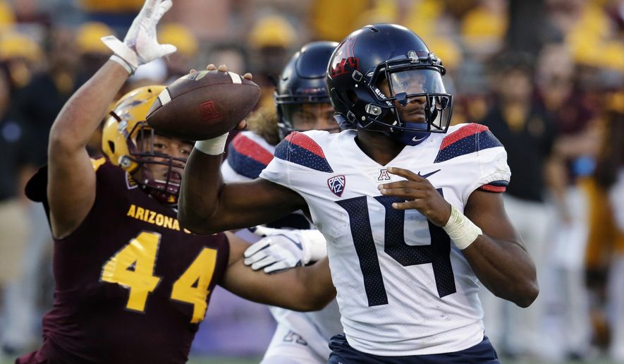FILE - In this Nov 25, 2017, file photo, Arizona quarterback Khalil Tate (14) throws while getting pressured by Arizona State linebacker Alani Latu during the second half of an NCAA college football game, in Tempe, Ariz. Tate went from starting last season as a backup quarterback to putting himself into the Heisman Trophy conversation with a stretch of eye-popping games (AP Photo/Rick Scuteri, File)
