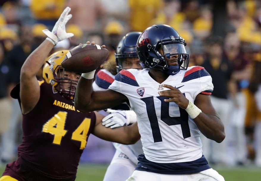 FILE - In this Nov 25, 2017, file photo, Arizona quarterback Khalil Tate (14) throws while getting pressured by Arizona State linebacker Alani Latu during the second half of an NCAA college football game, in Tempe, Ariz. Tate went from starting last season as a backup quarterback to putting himself into the Heisman Trophy conversation with a stretch of eye-popping games (AP Photo/Rick Scuteri, File)