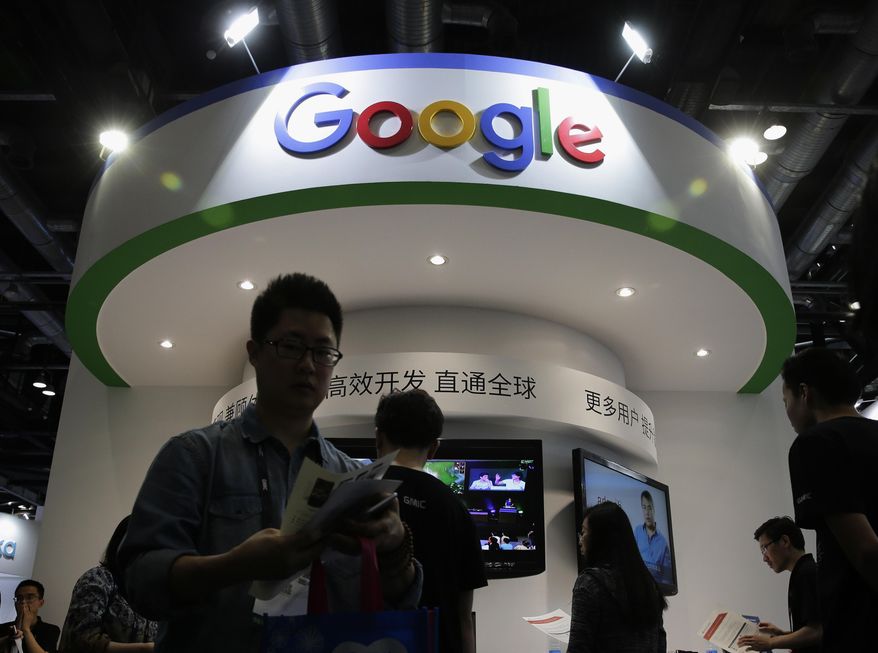 In this April 28, 2016, file photo, visitors gather at a display booth for Google at the 2016 Global Mobile Internet Conference (GMIC) in Beijing. (AP Photo/Andy Wong, File)