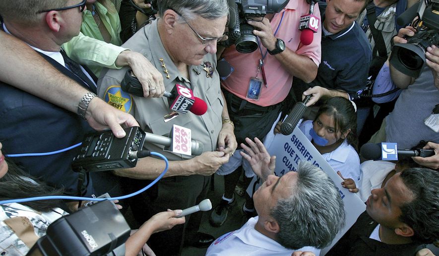 FILE _ In this July 14, 2006, file photo, Elias Bermudez kneels before then-Sheriff Joe Arpaio at a protest over the lawman's immigration crackdowns. Bermudez, who led the pro-immigrant group Immigrants Without Borders, lost a bid Thursday, Aug. 16, 2018, to move his Sept. 5 trial on federal tax charges out of Phoenix. He has pleaded not guilty to the charges. (AP Photo/Matt York,File)