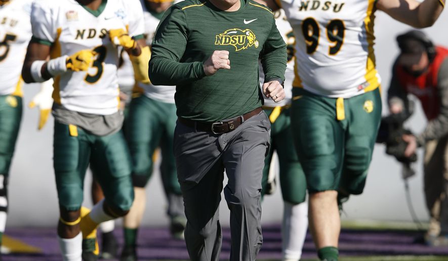FILE - In this Jan. 6, 2018, file photo, North Dakota State head coach Chris Klieman leads the team on the field before the FCS championship NCAA college football game against James Madison at Toyota Stadium in Frisco, Texas. The Bison have won six of the last seven Football Championship Subdivision titles, including last year’s victory over 2016 champ James Madison. Klieman’s team is picked at the top of all preseason FCS polls. (Vernon Bryant/The Dallas Morning News via AP, File)