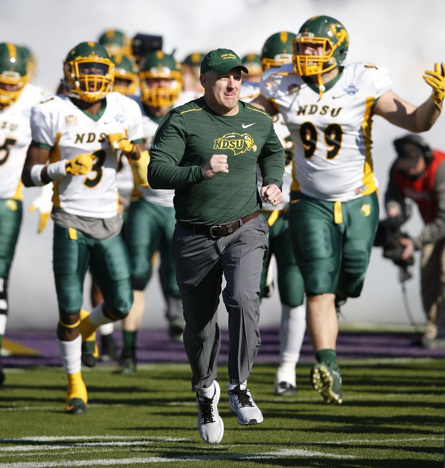 FILE - In this Jan. 6, 2018, file photo, North Dakota State head coach Chris Klieman leads the team on the field before the FCS championship NCAA college football game against James Madison at Toyota Stadium in Frisco, Texas. The Bison have won six of the last seven Football Championship Subdivision titles, including last year’s victory over 2016 champ James Madison. Klieman’s team is picked at the top of all preseason FCS polls. (Vernon Bryant/The Dallas Morning News via AP, File)