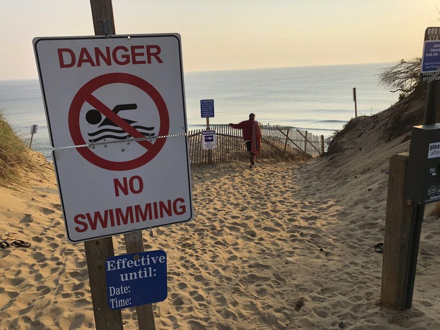 Steve McFadden, 49, of Plattsburgh, N.Y., gazes at Long Nook Beach in Truro, Mass., on Thursday, Aug. 16, 2018. Authorities closed the Cape Cod beach to swimmers after a man was attacked by a shark on Wednesday — the first attack on a person in Massachusetts since 2012. The unidentified victim survived the attack and was airlifted to a Boston hospital. (AP Photo/William J. Kole)