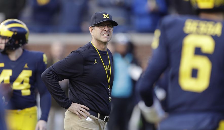 FILE - In this Nov. 25, 2017, file photo, Michigan coach Jim Harbaugh watches players warm up for an NCAA college football game against Ohio State in Ann Arbor, Mich. Harbaugh is 28-11 since taking over the Wolverines. That’s a clear improvement from where Michigan was, but a bit underwhelming considering the hype and expectations that accompanied Harbaugh’s arrival. Specifically, the Wolverines have struggled against their biggest rivals, going 1-5 against Ohio State and Michigan State. Michigan opens this season at Notre Dame. (AP Photo/Carlos Osorio, File)