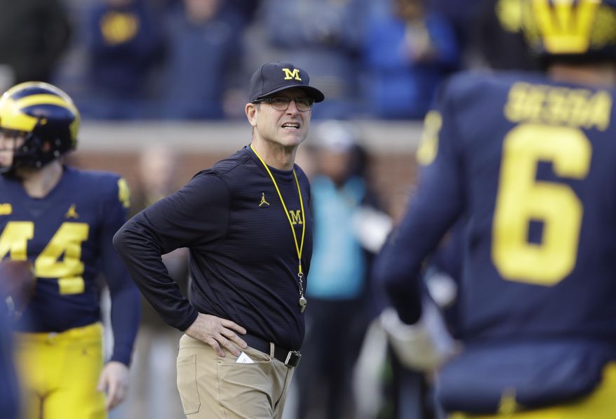 FILE - In this Nov. 25, 2017, file photo, Michigan coach Jim Harbaugh watches players warm up for an NCAA college football game against Ohio State in Ann Arbor, Mich. Harbaugh is 28-11 since taking over the Wolverines. That’s a clear improvement from where Michigan was, but a bit underwhelming considering the hype and expectations that accompanied Harbaugh’s arrival. Specifically, the Wolverines have struggled against their biggest rivals, going 1-5 against Ohio State and Michigan State. Michigan opens this season at Notre Dame. (AP Photo/Carlos Osorio, File)