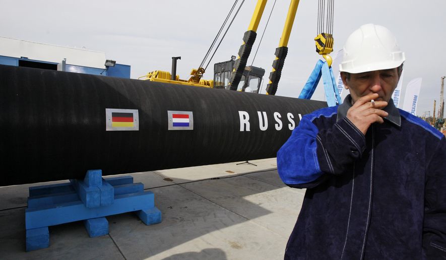FILE - In this Friday, April 9, 2010 file photo a Russian construction worker smokes in Portovaya Bay some 170 kms (106 miles) north-west from St. Petersburg, Russia, during a ceremony marking the start of Nord Stream pipeline construction. Merkel and Putin will meet on Saturday in the German government&#x27;s guesthouse Meseberg, north of Berlin, Saturday, Aug. 18, 2018. The topics will include the civil war in Syria, the conflict in Ukraine, and energy questions. (AP Photo/Dmitry Lovetsky, file)
