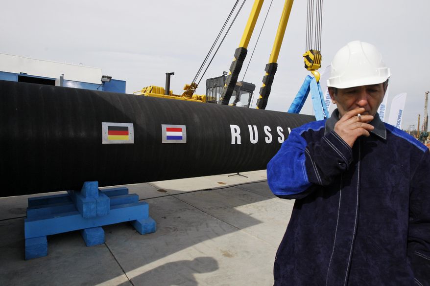 FILE - In this Friday, April 9, 2010 file photo a Russian construction worker smokes in Portovaya Bay some 170 kms (106 miles) north-west from St. Petersburg, Russia, during a ceremony marking the start of Nord Stream pipeline construction. Merkel and Putin will meet on Saturday in the German government&#x27;s guesthouse Meseberg, north of Berlin, Saturday, Aug. 18, 2018. The topics will include the civil war in Syria, the conflict in Ukraine, and energy questions. (AP Photo/Dmitry Lovetsky, file)