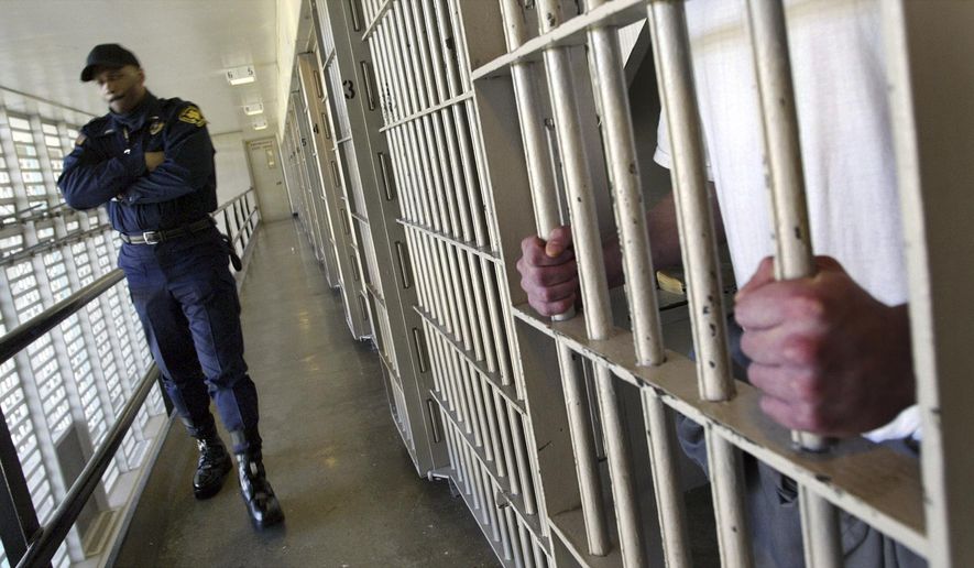 FILE - In this Feb. 2, 2005 file photo Washington state prisons Lt. Clan Jacobs walks through a block of cells at the Washington Corrections Center in Shelton, Wash. Three years after a federal judge said Washington state was violating the rights of mentally ill people warehoused in jails while they wait for competency services, the state has agreed to a plan to fix the problem. A settlement reached Thursday, Aug. 16, 2018, between Disability Rights Washington and the Department of Social and Health Services is designed to bring the state into compliance with the judge's order and end the contempt fines the state has been paying for years. (AP Photo/Ted S. Warren, File)