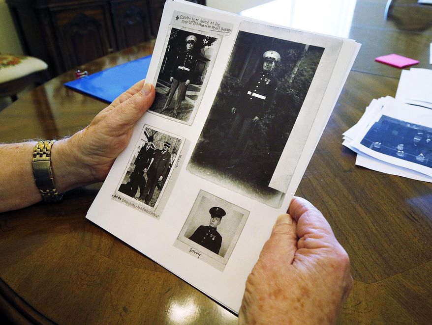 In this Thursday, Aug. 16, 2017 photo, Robert J. Holmes, nephew to Marine Pfc. Robert Kimball Holmes, shows photos of Pfc. Holmes in Draper, Utah. Pfc. Holmes, 19, of Salt Lake City, was killed during the attack on the USS Oklahoma in 1941 during World War II. A casket carrying his remains will arrive Friday night at the Salt Lake City International Airport. (Ravell Call/The Deseret News via AP)