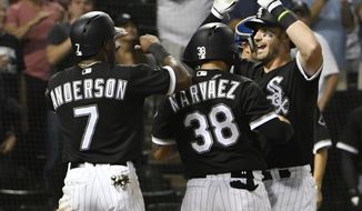 Chicago White Sox&#39;s Nicky Delmonico, right, is greeted by Omar Narvaez (38) and Tim Anderson (7) after hitting a three-run home run against the Kansas City Royals during the seventh inning of a baseball game Friday, Aug. 17, 2018, in Chicago. (AP Photo/David Banks)
