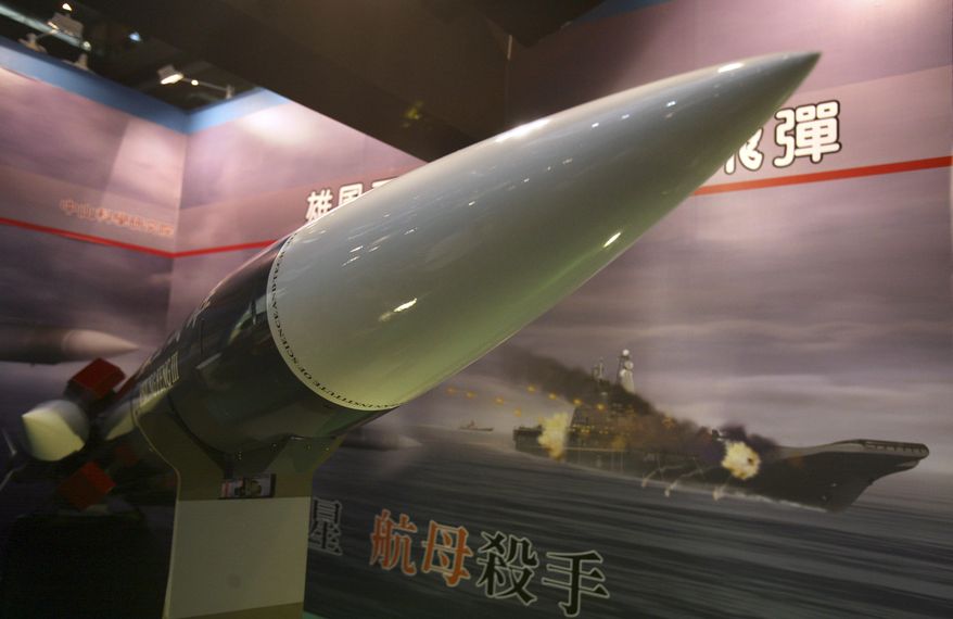 In this Aug. 10, 2011, file photo, Taiwan's indigenous Hsiung Feng III missile is propped against the backdrop of a billboard depicting a missile-riddled aircraft carrier, closely resembling China's carrier "Varyag," during a media preview of the Taipei Aerospace and Defense Technology show in Taipei, Taiwan. Chinese characters read: "Aircraft Carrier Killer." (AP Photo/Wally Santana, File)