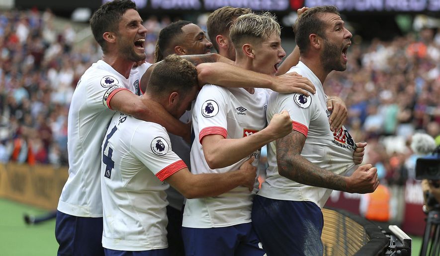 Bournemouth's Steve Cook, right, celebrates scoring his side's second goal of the game against West Ham during their English Premier League soccer match at London Stadium in London, Saturday Aug. 18, 2018. (Nigel French/PA via AP)
