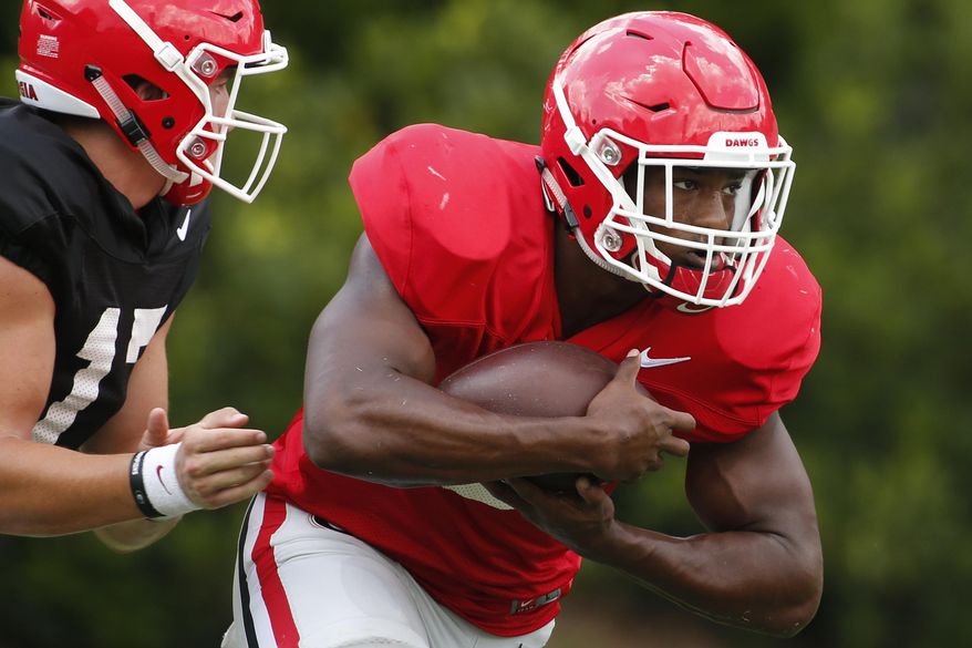 In this Aug. 9, 2018 file photo Georgia running back Zamir White (3) takes a hand off from quarterback Matthew Downing (17) during an NCAA college football practice in Athens, Ga. White suffered his second anterior cruciate ligament injury in less than a year on Saturday, Aug. 18, 2018 likely ending his hopes of playing in 2018. (Joshua L. Jones/Athens Banner-Herald via AP)