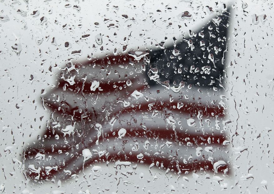 An American flag is seen through rain drops on a window as rain falls in Baltimore, Sunday, April 22, 2012. (AP Photo/Patrick Semansky)