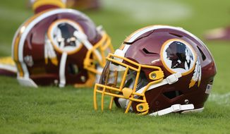 A Washington Redskins football helmet lies on the field before a preseason NFL football game against the New York Jets, Thursday, Aug. 16, 2018, in Landover, Md. (AP Photo/Nick Wass) ** FILE **
