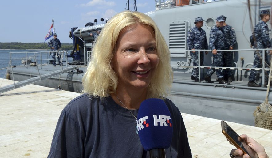 In this photo taken Aug. 19, 2018, a woman who identified herself as Kay from England, is interviewed by local media in front of a Croatian Coast Guard vessel in the port in Pula, Croatia. A British woman was rescued Sunday after falling from a cruise ship and spending 10 hours in the Adriatic Sea at night, Croatia&#x27;s coast guard said. (AP Photo)
