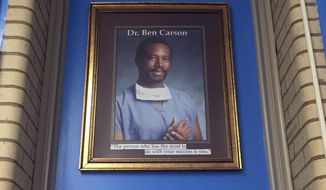In this May 3, 2018, photo, a portrait of Ben Carson hangs in the Ben Carson Reading Room inside of the Archbishop Borders School in Baltimore. The portrait used to hang in the school&#39;s hallway, but Principal Alicia Freeman moved it out of public view during Carson&#39;s presidential campaign. Carson’s story of growing up in a single-parent household and climbing out of poverty to become a world-renowned surgeon was once ubiquitous in Baltimore, where Carson made his name. But his role in the Trump Administration has added a complicated epilogue, leaving many who admired him feeling betrayed, unable to separate him from the politics of a president widely rejected by African Americans here.  (AP Photo/Juliet Linderman)