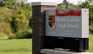 Paint covers the name of Cardinal Wuerl at Cardinal Wuerl North Catholic High School, on Monday, Aug. 20, 2018, in Cranberry Township, Pa. Wuerl, a Roman Catholic Cardinal, and the archbishop of Washington, D.C., has come under fire from revelations in the Pennsylvania grand jury report about his actions while bishop of Pittsburgh. (AP Photo/Keith Srakocic)