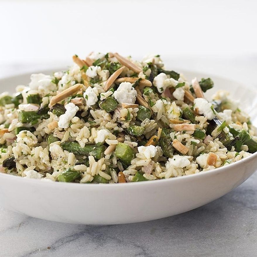 This undated photo provided by America's Test Kitchen in August 2018 shows a brown rice salad with asparagus and goat cheese in Brookline, Mass. This recipe appears in the cookbook "Holiday Entertaining." (Carl Tremblay/America's Test Kitchen via AP)