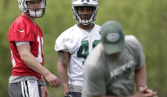 FILE - In this May 5, 2018, file photo, New York Jets first-round pick, Sam Darnold, left, and sixth round pick, Trenton Cannon, center, watch as offensive coordinator Jeremy Bates shows them a maneuver during NFL rookie camp in Florham Park, N.J. Bates already knew Darnold was pretty special from working with the No. 3 overall draft pick in the offseason. (AP Photo/Julio Cortez, File)