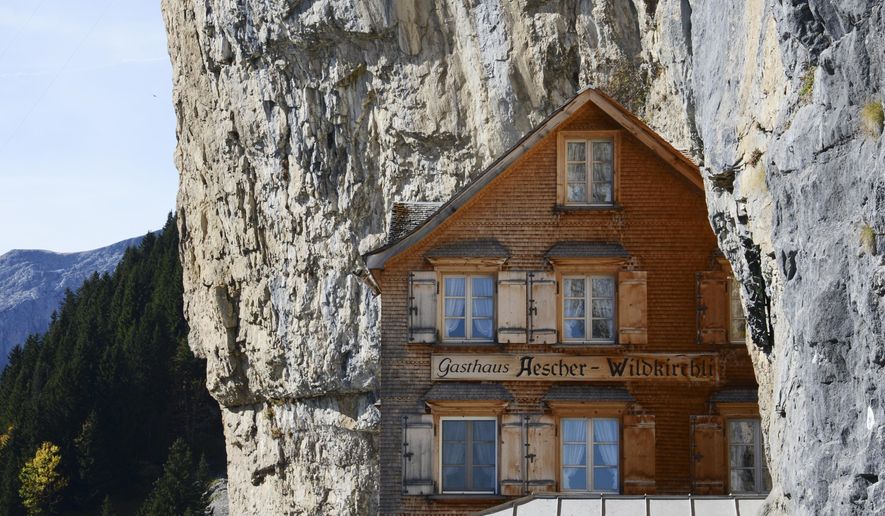 FILE - In this Oct. 14, 2014 file photo people take a break outside the Gasthaus Aescher near Ebenalp, Switzerland. The Gasthaus Aescher, built into a cliff above a valley in northeastern Switzerland, has been run by the same family since 1987. Authorities in Appenzell-Innerrhoden canton said Monday, Aug. 20, 2018 that the current tenants, Nicole and Bernhard Knechtle-Fritsche, are giving up the lease at the end of the 2018 season. (Steffen Schmidt/Keystone via AP)