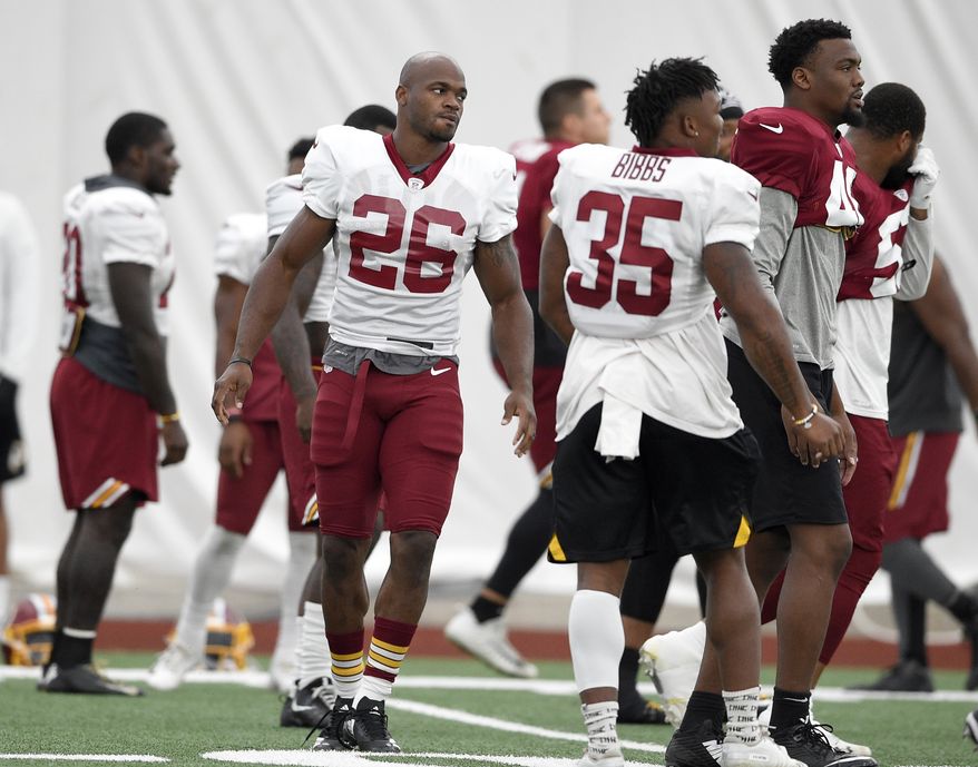 Washington Redskins running back Adrian Peterson (26) warms up next to running back Kapri Bibbs (35) during an NFL football team practice, Tuesday, Aug. 21, 2018, in Ashburn, Va. (AP Photo/Nick Wass) **FILE**
