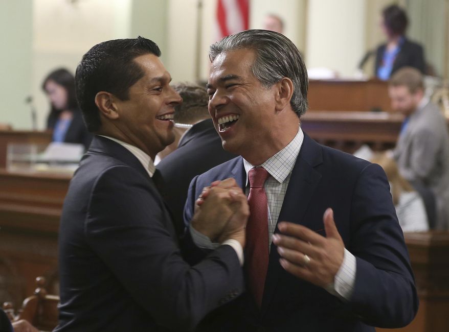 Assemblyman Rob Bonta, D-Alameda, right, receives congratulations from Assemblyman Miguel Santiago, D-Los Angeles, after the California Assembly approved the bail reform bill he co-authored with Sen. Bob Hertzberg, D-Van Nuys, Monday, Aug. 20, 2018, in Sacramento, Calif. The bill was sent to the Senate for a final vote. (AP Photo/Rich Pedroncelli)