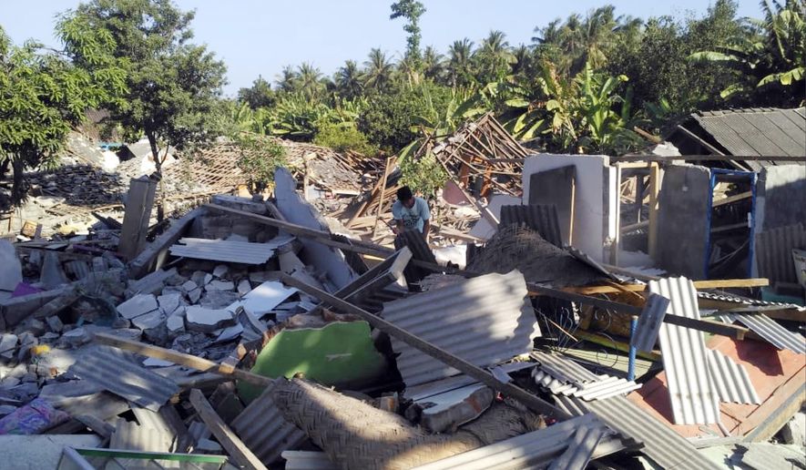A man inspects destroyed homes following an earthquake on Lombok island, Indonesia, Monday, Aug. 20, 2018. Multiple strong earthquakes killed a number of people on the Indonesian islands of Lombok and Sumbawa as the region was trying to recover from a temblor earlier this month that killed hundreds of people. (AP Photo/Fauzy Chaniago)