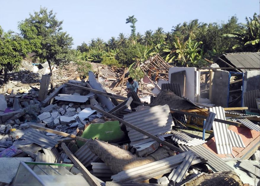 A man inspects destroyed homes following an earthquake on Lombok island, Indonesia, Monday, Aug. 20, 2018. Multiple strong earthquakes killed a number of people on the Indonesian islands of Lombok and Sumbawa as the region was trying to recover from a temblor earlier this month that killed hundreds of people. (AP Photo/Fauzy Chaniago)