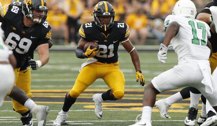 FILE - In this Sept. 16, 2017, file photo, Iowa running back Ivory Kelly-Martin (21) runs from North Texas linebacker Joe Ozougwu, right, during the second half of an NCAA college football game, in Iowa City, Iowa. Sophomore Ivory Kelly-Martin will likely start the season as Iowa’s top running back, according to offensive coordinator Brian Ferentz.The move could be categorized as a mild surprise given that fellow sophomore Toren Young was listed ahead of Kelly-Martin on a depth chart released earlier in fall camp. But Kelly-Martin, who appeared to be slotted as an option on third downs and in the return game, has shown Iowa’s coaches that he has the potential to an every down back in their system.The Hawkeyes (8-5 in 2017) host Northern Illinois on Sept. 1. (AP Photo/Charlie Neibergall, FIle)