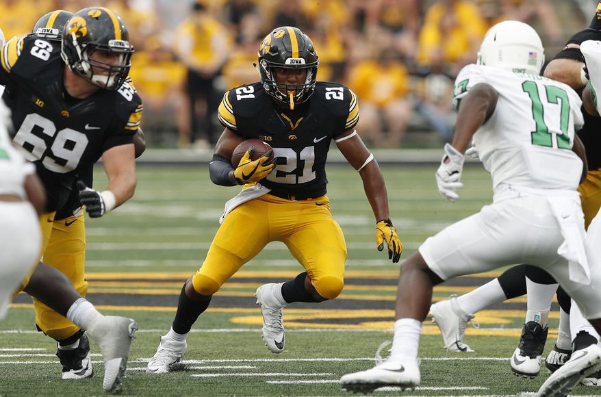 FILE - In this Sept. 16, 2017, file photo, Iowa running back Ivory Kelly-Martin (21) runs from North Texas linebacker Joe Ozougwu, right, during the second half of an NCAA college football game, in Iowa City, Iowa. Sophomore Ivory Kelly-Martin will likely start the season as Iowa’s top running back, according to offensive coordinator Brian Ferentz.The move could be categorized as a mild surprise given that fellow sophomore Toren Young was listed ahead of Kelly-Martin on a depth chart released earlier in fall camp. But Kelly-Martin, who appeared to be slotted as an option on third downs and in the return game, has shown Iowa’s coaches that he has the potential to an every down back in their system.The Hawkeyes (8-5 in 2017) host Northern Illinois on Sept. 1. (AP Photo/Charlie Neibergall, FIle)