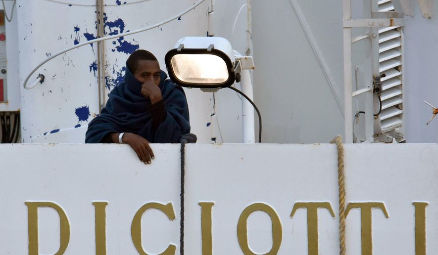 A man stands on the deck of the Italian Coast Guard ship "Diciotti" moored at the Catania harbor Tuesday, Aug. 21, 2018. The European Union is trying to find countries willing to take 177 people rescued at sea after Italy sought its help to deal with yet another migrant standoff with Malta. The Italian coast guard ship Diciotti that had been sitting off Italy’s Lampedusa island entered Catania's harbor. Rome asked Malta to take them in but Malta, the EU’s smallest member country _ refused, saying the migrant boat wasn't in distress and that the migrants declined Maltese assistance, preferring to continue toward Italy. (Orietta Scardino/ANSA via AP)