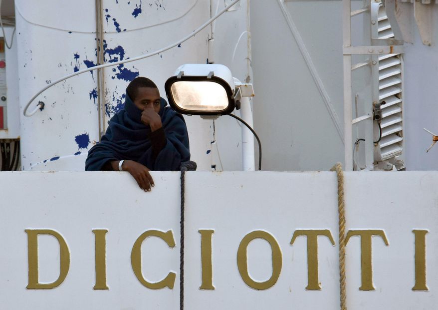 A man stands on the deck of the Italian Coast Guard ship "Diciotti" moored at the Catania harbor Tuesday, Aug. 21, 2018. The European Union is trying to find countries willing to take 177 people rescued at sea after Italy sought its help to deal with yet another migrant standoff with Malta. The Italian coast guard ship Diciotti that had been sitting off Italy’s Lampedusa island entered Catania's harbor. Rome asked Malta to take them in but Malta, the EU’s smallest member country _ refused, saying the migrant boat wasn't in distress and that the migrants declined Maltese assistance, preferring to continue toward Italy. (Orietta Scardino/ANSA via AP)