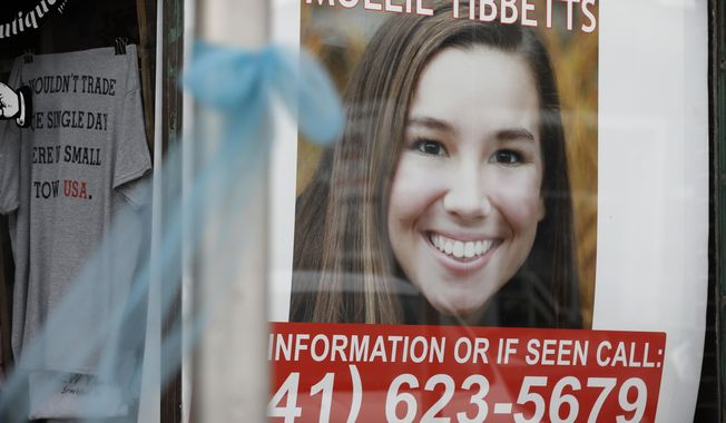 A poster for missing University of Iowa student Mollie Tibbetts hangs in the window of a local business, Tuesday, Aug. 21, 2018, in Brooklyn, Iowa. Tibbetts was reported missing from her hometown in the eastern Iowa city of Brooklyn in July 2018. (AP Photo/Charlie Neibergall)
