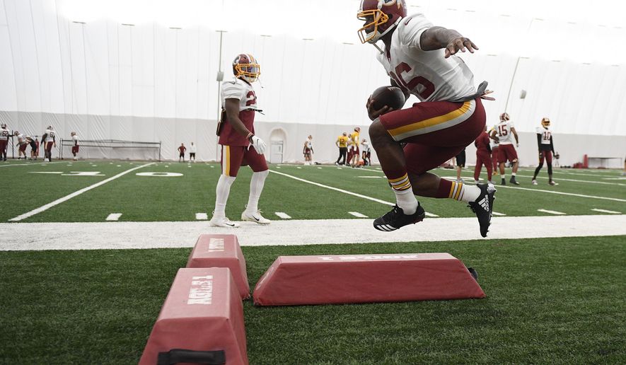 Washington Redskins running back Adrian Peterson runs with the ball during an NFL football team practice, Tuesday, Aug. 21, 2018, in Ashburn, Va. (AP Photo/Nick Wass)