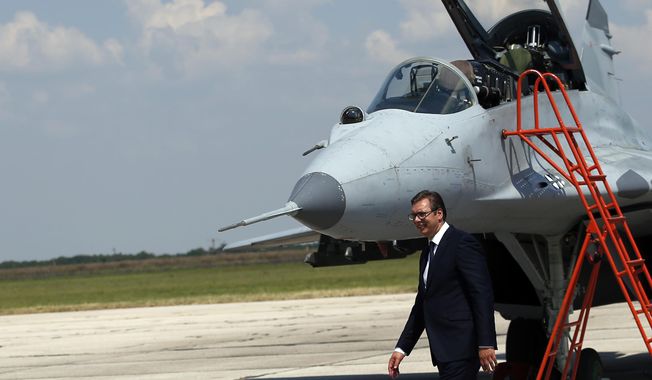 Serbian President Aleksandar Vucic walks by a MiG-29 jet fighter on the tarmac at Batajnica, military airport near Belgrade, Serbia, Tuesday, Aug. 21, 2018. Serbia&#x27;s air force has taken the delivery of two Russian MiG-29 fighter jets, part of an arms purchase that has the potential to heighten tensions in the Balkans and increase Moscow&#x27;s influence in the region. (AP Photo/Darko Vojinovic)